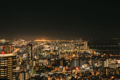 High angle view of illuminated buildings against sky at night