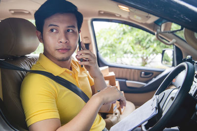Portrait of young man sitting in car
