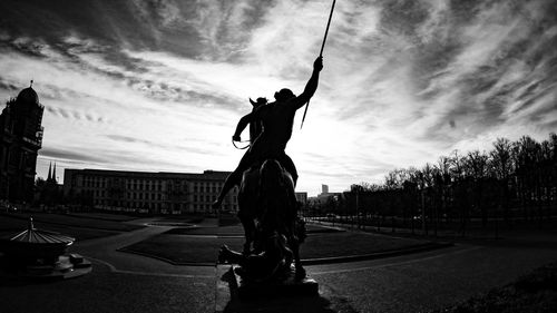 Woman on road in city against sky