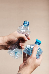 Close-up of hands holding plastic bottles