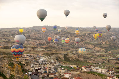 Hot air balloons flying over landscape against sky