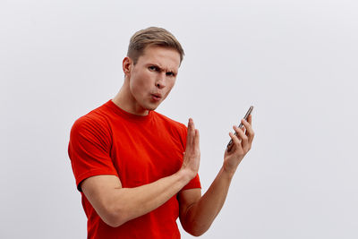 Young man using mobile phone against white background