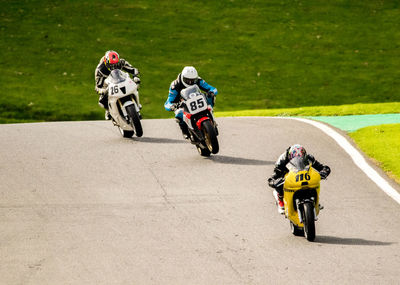 Rear view of people riding motorcycle