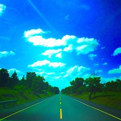 Empty road leading towards dramatic sky