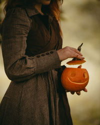 Redhead woman holding halloween pumpkin