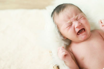 Crying baby boy asian. newborn child tired and hungry in hand mother. 