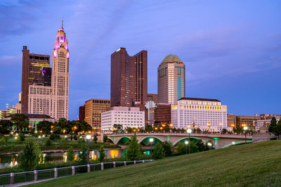 Buildings in city against cloudy sky