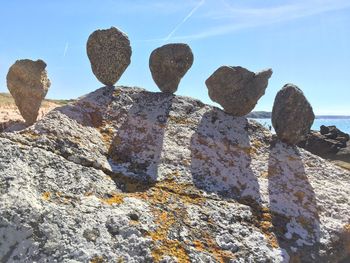 Low angle view of rocks on shore against sky