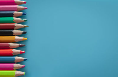 Directly above shot of multi colored pencils against blue background