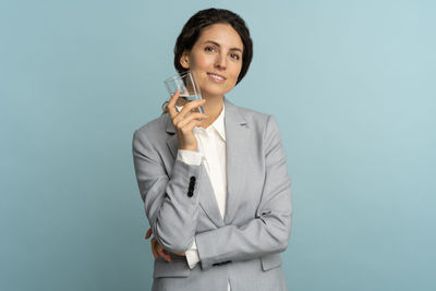 Portrait of a smiling young woman against gray background