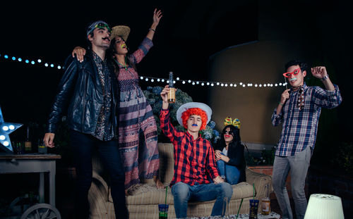 Cheerful friends celebrating on roof top at night