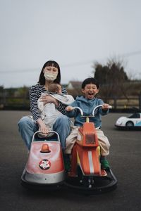 Portrait of smiling couple sitting on road