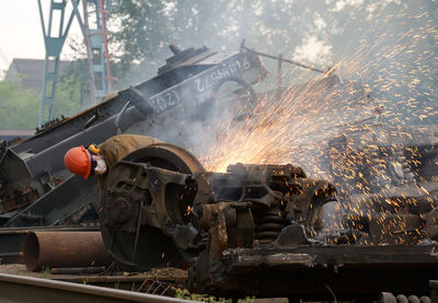 Welder welding scrap metal of train