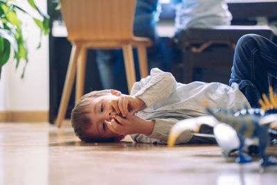 Portrait of happy boy lying down on floor