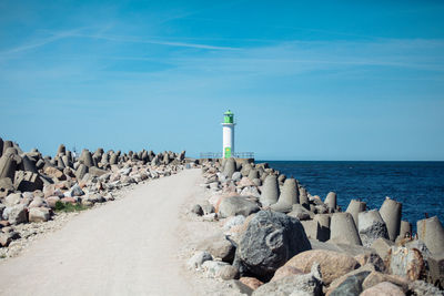 Lighthouse by sea against sky