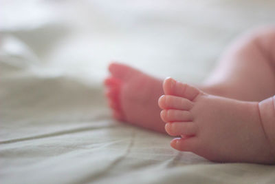 Low section of baby feet on bed