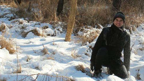 Portrait of smiling young woman standing in snow