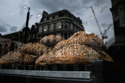 Close-up of bread in glass container against building