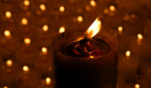 Close-up of lit tea light candles in temple