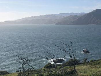 Scenic view of sea and mountains against sky