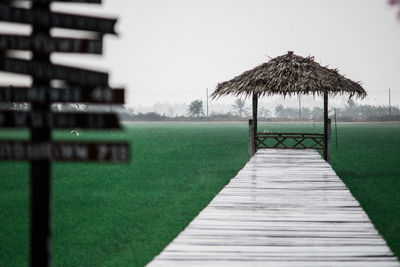 Wooden structure on footpath against clear sky