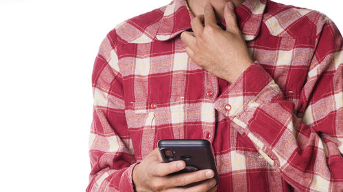 Midsection of man holding mobile phone against white background