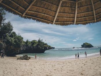 People on beach against sky