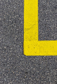 High angle view of yellow arrow symbol on road