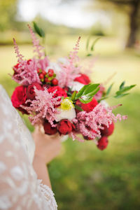 Midsection of woman holding rose bouquet