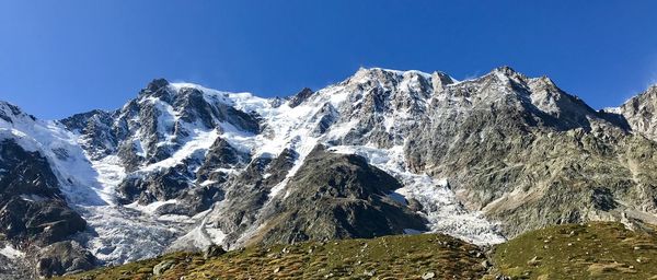 Scenic view of snowcapped mountains against clear blue sky