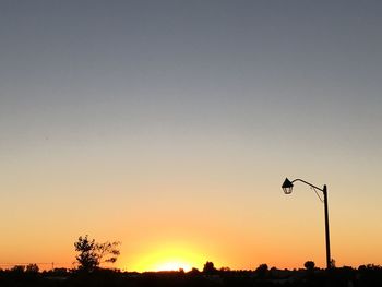 Silhouette landscape against clear sky at sunset