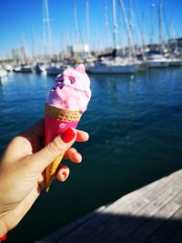 Hand holding ice cream cone in water