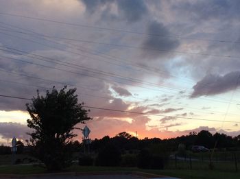 Silhouette of trees on field against sky at sunset