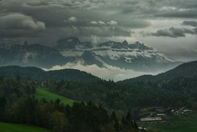 Scenic view of mountains against cloudy sky