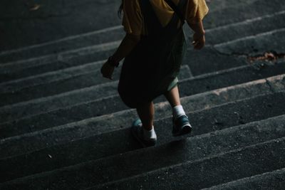 Low section of woman walking on steps