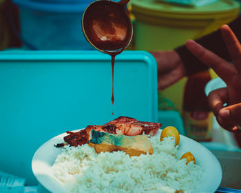 Close-up of hand holding ice cream in plate