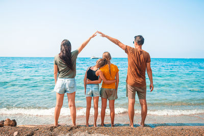 People standing at beach against sky