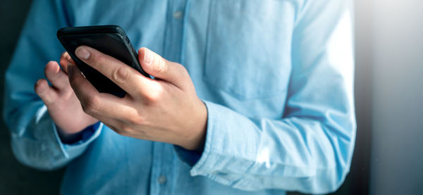 Midsection of man using mobile phone