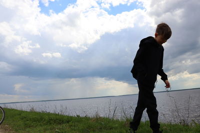 Full length of man standing by lake against sky