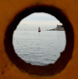 Reflection of woman in sea against sky