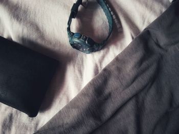 Close-up of human hand on bed