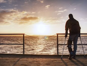 Rear view of man looking at sea against sky