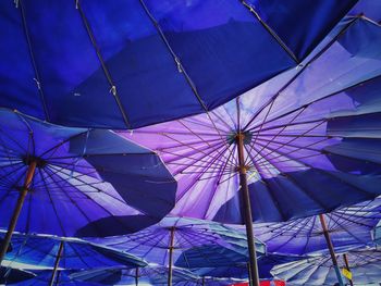 Low angle view of umbrella against blue sky