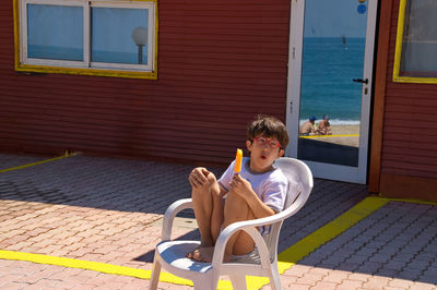 Portrait of boy sitting on brick wall