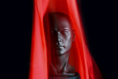 Close-up portrait of buddha statue against black background