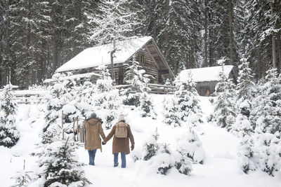 Young couple holding hands while walking on snow