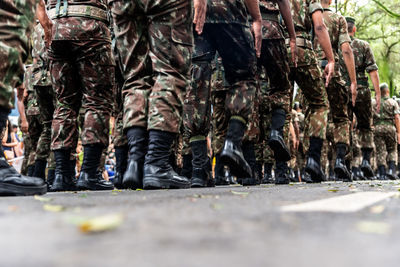  low view of the legs of brazilian army soldiers marching through the streets 