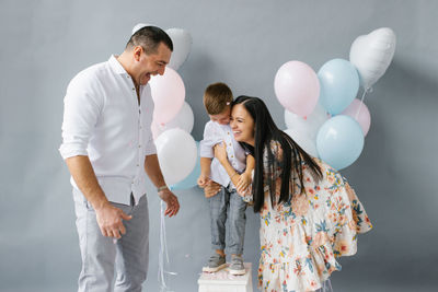 Gender reveal party. a stylish beautiful family with a child laughing merrily against the background