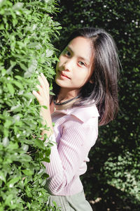 Portrait of woman standing against plants