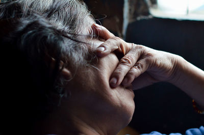 Close-up of depressed woman covering eyes at home